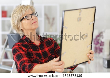 woman holding photo frame at home