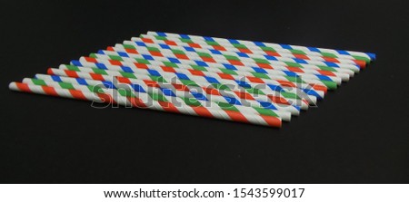 Paper straw of different colors on dark background