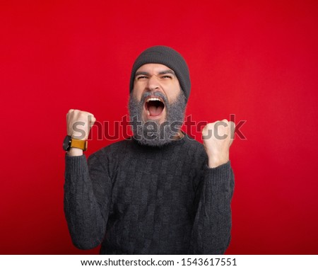 Close up photo of screaming man celebrating over red background