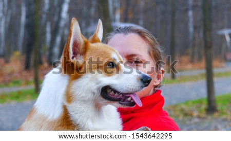 Corgi dog with his owner close up face in autumn park