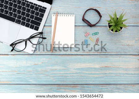 Flat lay business office concept on vintage wooden table desk with blank notepad and laptop computer, supplies, Top view with copy space, work space