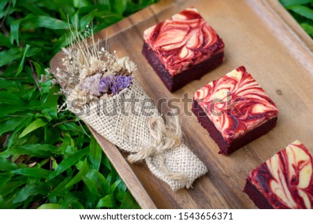 Red velvet cream cheese brownies on wooden plate Royalty-Free Stock Photo #1543656371