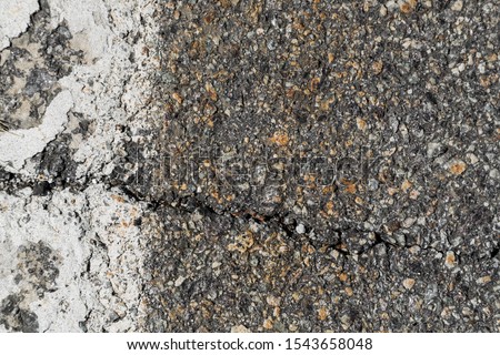 Broken and rough asphalt texture with white line on the left.