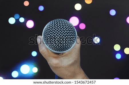 The hand holding the microphone sing and Beautiful bokeh background