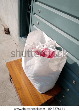 Eco Friendly Reusable Bag for cloth, Non Woven Bag, white Polypropylene Shopping Bag on table