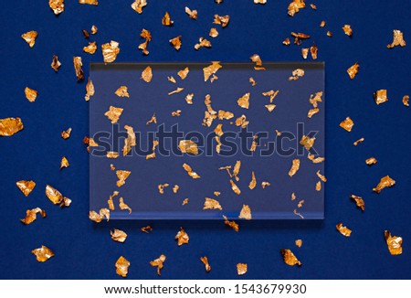 Gold foil concept Christmas or New Year festive frame on the blue paper background. Copy space