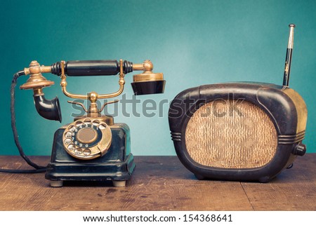 Vintage telephone, old retro radio on wood table