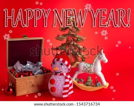 Festive composition with pleasant wishes, a snowman, Christmas toys and a horse on a red background with snowflakes.