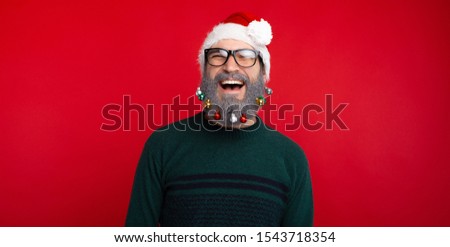 Photo of happy smiling man with decorated beard standing over red background
