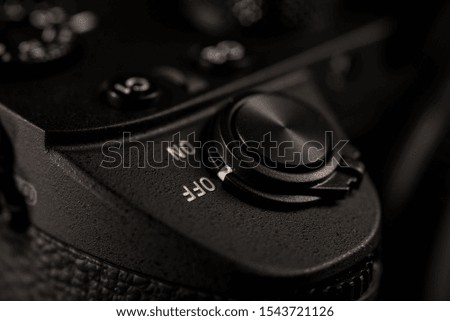 ON OFF selector switch of mirrorless camera against black background.