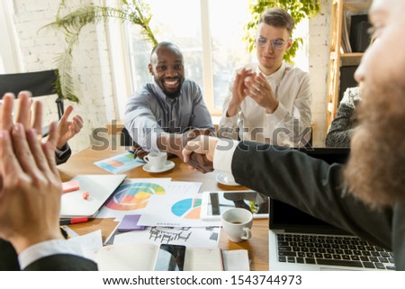 Group of young business professionals having a meeting. Diverse group of coworkers discuss new decisions, future plans and strategy. Creative meeting and workplace, business, finance, teamwork.