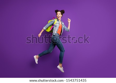 Shopping time! Full size profile photo of funny student lady jumping high glad to finish study rushing mall wear green bag casual denim outfit isolated purple color background