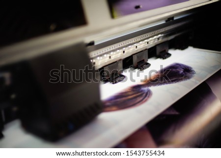 Large inkjet printer with printing on vinyl paper with lighting in workplace