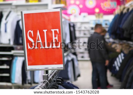 Sale sign notice into a clothes store. Shopping mall advertisement.