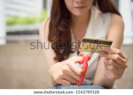 Female hands cutting credit card with scissors.
Young woman destroy credit card, debt problem concept. Royalty-Free Stock Photo #1543789328