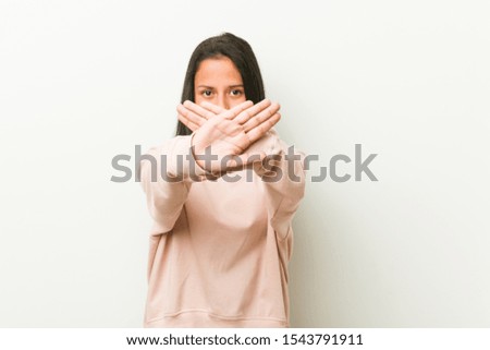 Young cute hispanic teenager woman doing a denial gesture