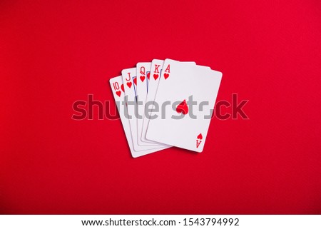 Hearts royal flash cards on a red table. Poker casino game. Top view.