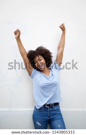 Portrait of cheerful young african american woman with arms raised  Royalty-Free Stock Photo #1543805315