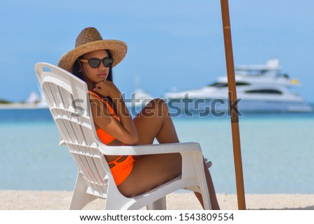 beautiful girl resting chair under beach umbrella