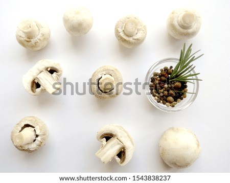Healthy food cooking. Fresh champignon mushrooms with pepper seeds and rosemary in bowl on white background. Flat lay. Royalty-Free Stock Photo #1543838237