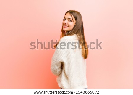 young pretty woman smiling gleefully, feeling happy, satisfied and relaxed, with crossed arms and looking to the side against pink background Royalty-Free Stock Photo #1543866092