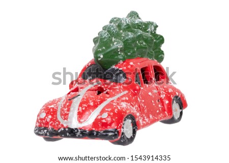 Christmas decorations background. Closeup of a snow-covered red car toy with green fir-tree on the roof isolated on a white background. Saisonal design element for cards or stickers. Macro.