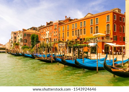 picturesque view at a berth in a Venice chanel with gondolas and nice old builginds on background , cozy cafe , Grand chanel , venetian street and palace