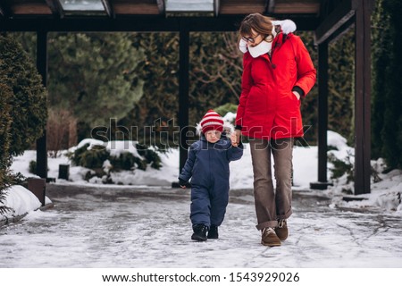 Mother with little son outside in winter