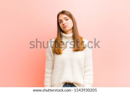 young pretty woman feeling sad and whiney with an unhappy look, crying with a negative and frustrated attitude against pink background Royalty-Free Stock Photo #1543930205