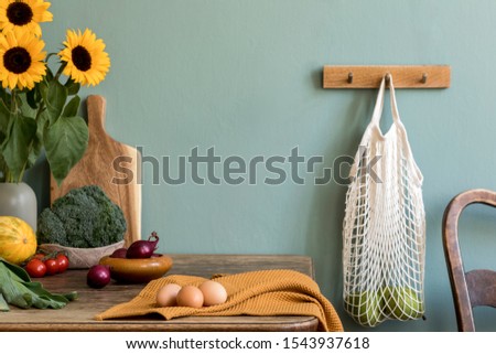 Vintage kitchen interior with wooden table, bag with apples, fruits, vegetables, eggs, sunflowers and kitchen accessories. Minimalistic concept of kitchen space. Template. Copy space. Ready to use.