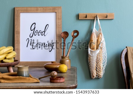 Vintage kitchen interior with wooden table, bag with bagles, eggs, cup of tea and kitchen accessories. Minimalistic concept of kitchen space. Country side mood. Template. Mock up picture frame. 