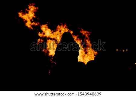 People watching fire burning at night