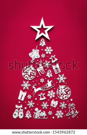 Merry christmas tree concept made of white 2022 happy new year decorated wooden toys star on top view isolated on red background table minimal flat lay, merry winter holiday party, vertical