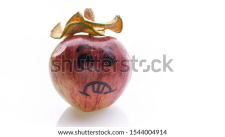 Face painted apples. Sad red apples on a white background.