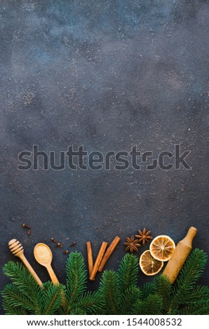 Christmas culinary background for menu or recipe. Spices for baking and fir branches on dark concrete. Top view or flat lay. Copy Space. Royalty-Free Stock Photo #1544008532