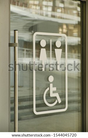 Disabled sign and arrow on glass doors