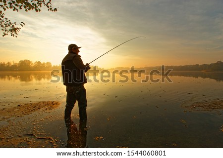angler catching fish in the lake during cloudy sunrise
 Royalty-Free Stock Photo #1544060801
