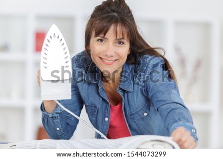 a happy woman doing ironing
