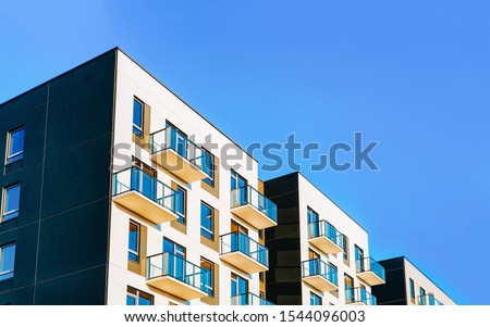 Fragment of Modern residential apartment with flat buildings exterior. Detail of New luxury house and home complex. Part of City Real estate property and condo architecture. Copy space. Blue sky Royalty-Free Stock Photo #1544096003