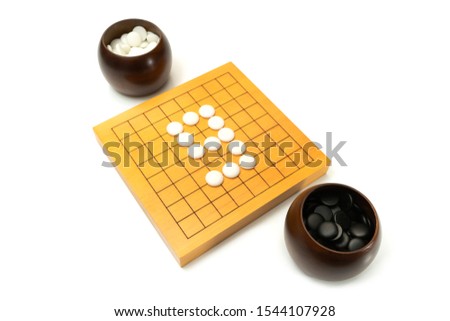 number 9 shape of white stone on wood board game GO (Weiqi, Baduk, Goban, iGo) - strategy board game size 9 by 9