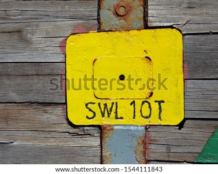 Tie-down lug painted yellow on deck of a construction vessel with marking SWL 10T (safe working load of ten tonne)
