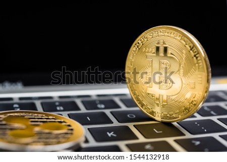 Virtual golden Bitcoin coin currency finance money on computer laptop keyboard