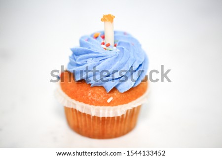 Teal birthday cupcake with butter cream icing isolated on white. - Image