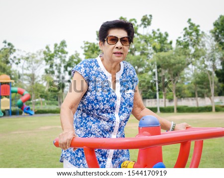 Asian senior woman doing exercise with outdoor equipment, lifetyle concept.