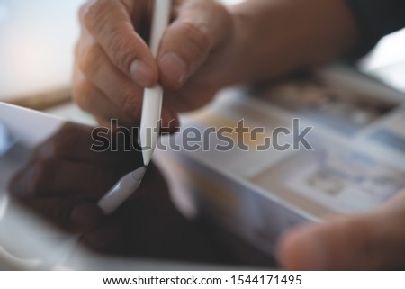 Interior designer, business man, graphic designer working with stylus pen, using drawing apps on digital tablet with home plan on desk in studio office. Home decorator using tablet computer, close up