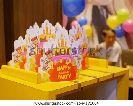 Paper hats for a birthday party are placed on a table ready to be picked up and put on by guests who join the event