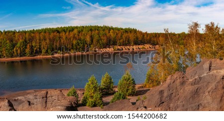 Beautiful autumn view of the iron mine lake colored red at Bad Muskau Park, Poland site. Royalty-Free Stock Photo #1544200682
