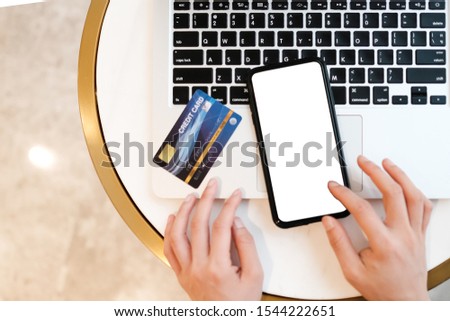 Close up of topview woman using blank cell phone and credit card sending massages shopping online on the coffee shop.