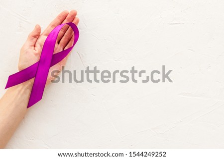 Lilac ribbon in hands is symbol of Alzheimers disease on white background top view copy space
