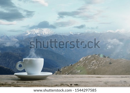 Single tea or coffee mug and landscape of mountains on background. Cup of hot drink sunshine look and clear sky in front of it. Warm in spring day, holidays, travel, adventure time.